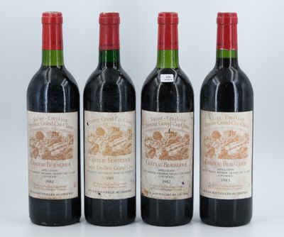 three bottles of red wine sit next to each other on a white surface