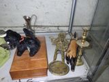 a black teddy bear sitting on top of a table next to other items