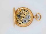 a close up of a pocket watch on a white surface