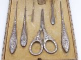 five pairs of scissors in a box on a table