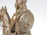 bronze statue of a man on a horse with a shield on his head