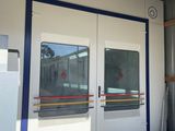 porte d'un immeuble devant laquelle se trouvent un réfrigérateur et un réfrigérateur-congélateur