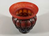 a red vase with a black base on a white background