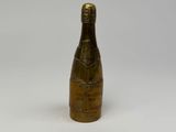 an old bottle of champagne sitting on top of a white table