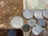 a pile of coins on a table next to a bank note