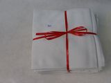 a stack of folded napkins tied with a red ribbon