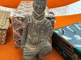 a statue of a man sitting on a chair next to a box
