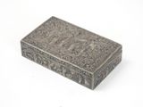 une vieille boîte en argent ornée d'un motif sur fond blanc
