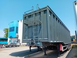 un camion garé sur un terrain avec d'autres camions à l'arrière-plan