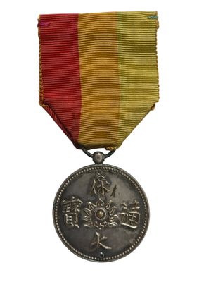 une vieille médaille sur laquelle figure une inscription en chinois sur fond blanc