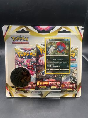 un gros plan sur une boîte de cartes Pokémon avec une pièce de monnaie