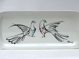a white tray with two birds painted on it