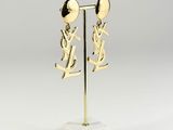 a pair of gold earrings on a marble stand