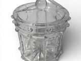 a glass jar with a spoon in it on a white surface