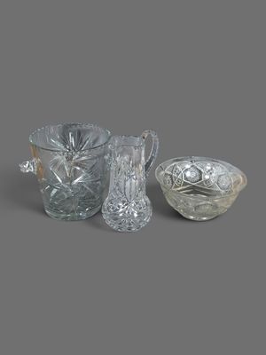 trois vases en verre et un bol posés sur une surface grise
