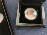 a silver coin with a picture of a woman in a blue dress