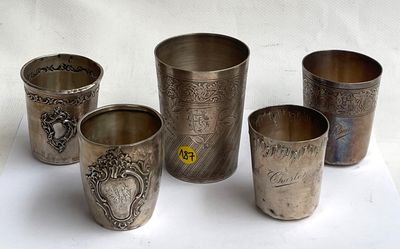 quatre coupes en argent ornées de motifs, posées sur une surface blanche