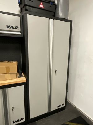 une armoire de rangement dans un garage, avec une boîte posée dessus