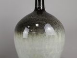 un vase noir et blanc posé sur une table