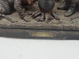 a statue of a man and a boy with a pot on a table