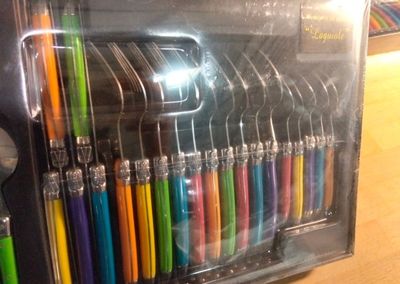 many different colored pens and spoons in a display case