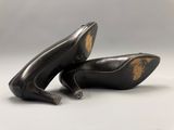 a pair of black high heeled shoes sitting on top of each other