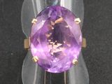 une bague en amethorate sur une surface noire, ornée d'une bande dorée