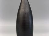 a black vase that is sitting on a white surface