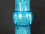 un vase bleu posé sur une surface noire