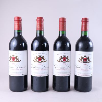 trois bouteilles de vin rouge sont alignées sur une surface blanche