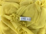 yellow chiffon fabric with ruffles and a label on it