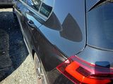 a black car parked in a parking lot with other cars