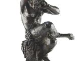 statue of a man sitting on a rock with a dog
