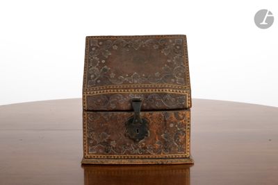 une petite boîte en bois posée sur une table, contenant une clé