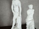 deux statues représentant un homme et une femme posées sur une table
