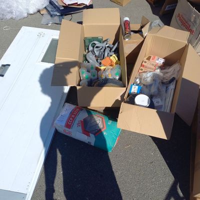 une boîte en carton remplie d'objets, posée par terre