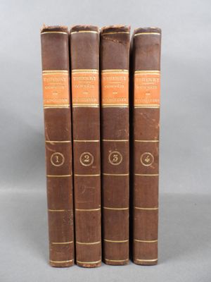 four old books sitting on top of each other on a table
