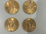 quatre pièces d'or posées sur une surface blanche