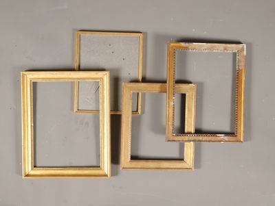 trois cadres dorés accrochés au mur, avec un miroir au milieu