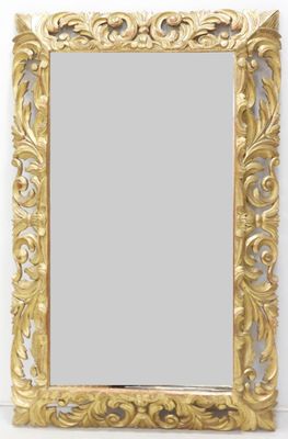 un miroir au cadre doré ouvragé accroché à un mur sur fond blanc