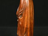 a wooden statue of a woman with a hood on her head