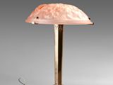 a lamp with a pink shade sitting on top of a table