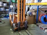 a forklift in the middle of a room with lots of boxes