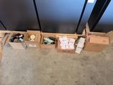 Plusieurs cartons contenant des objets divers sont alignés sur le sol.