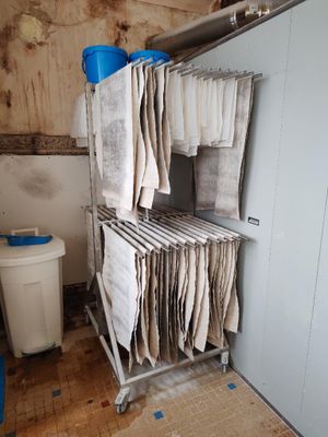 une photo d'une salle de bains sale avec de nombreuses serviettes suspendues au porte-serviettes