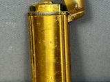 a gold lighter that is sitting on a wooden table