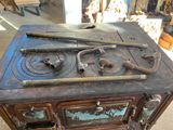 an old stove that has some tools on top of it
