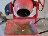 une bétonnière rouge posée sur un chariot dans un garage