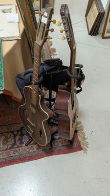 une guitare et d'autres instruments de musique exposés dans une pièce