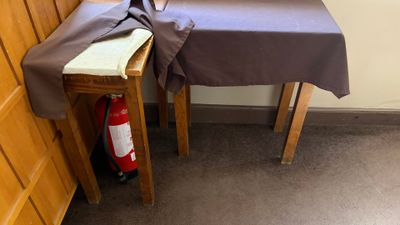 a table with a brown cloth on it next to a fire extinguisher